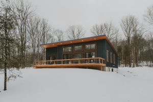 Modern house with wooden deck in snowy landscape